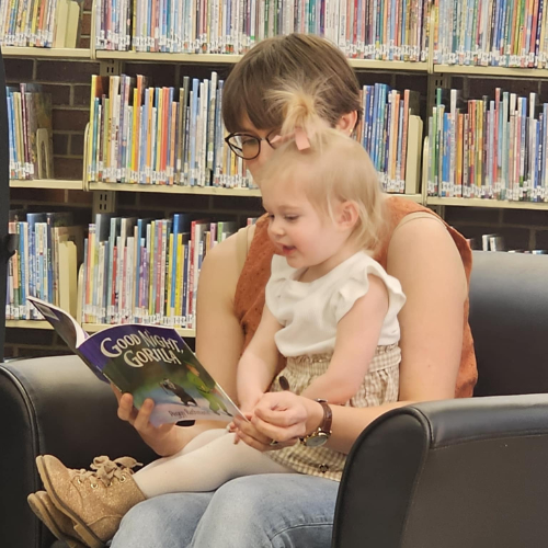 A mother reading to her daughter.