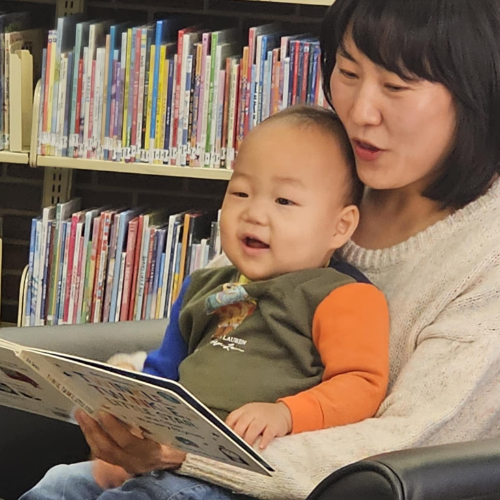 Mother reading a book to her son.