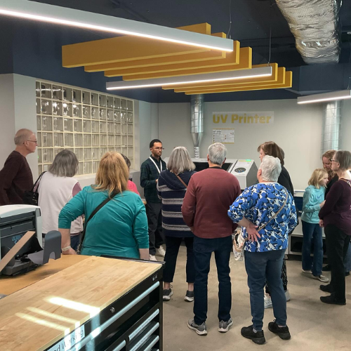 Patrons gathered around the UV printer in the Maker Lab